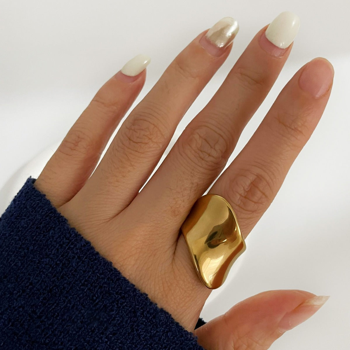 Skulptural ring i rostfritt stål guld minimalistisk design sedd på hand
