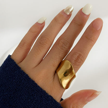 Skulptural ring i rostfritt stål guld minimalistisk design sedd på hand