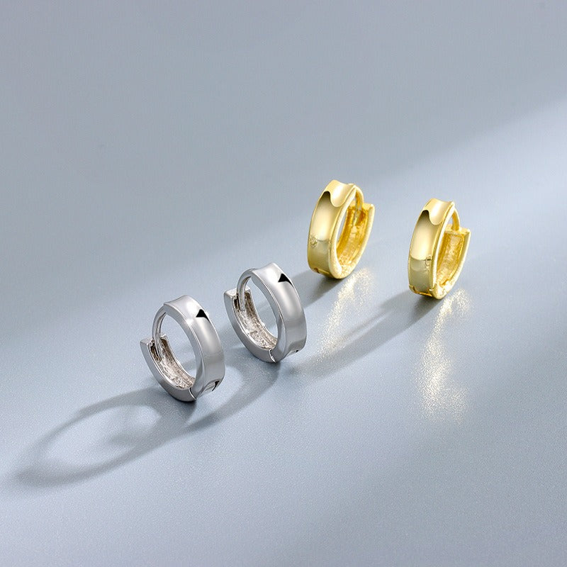 små hoop örhängen silver och guld liggandes bredvid varandra