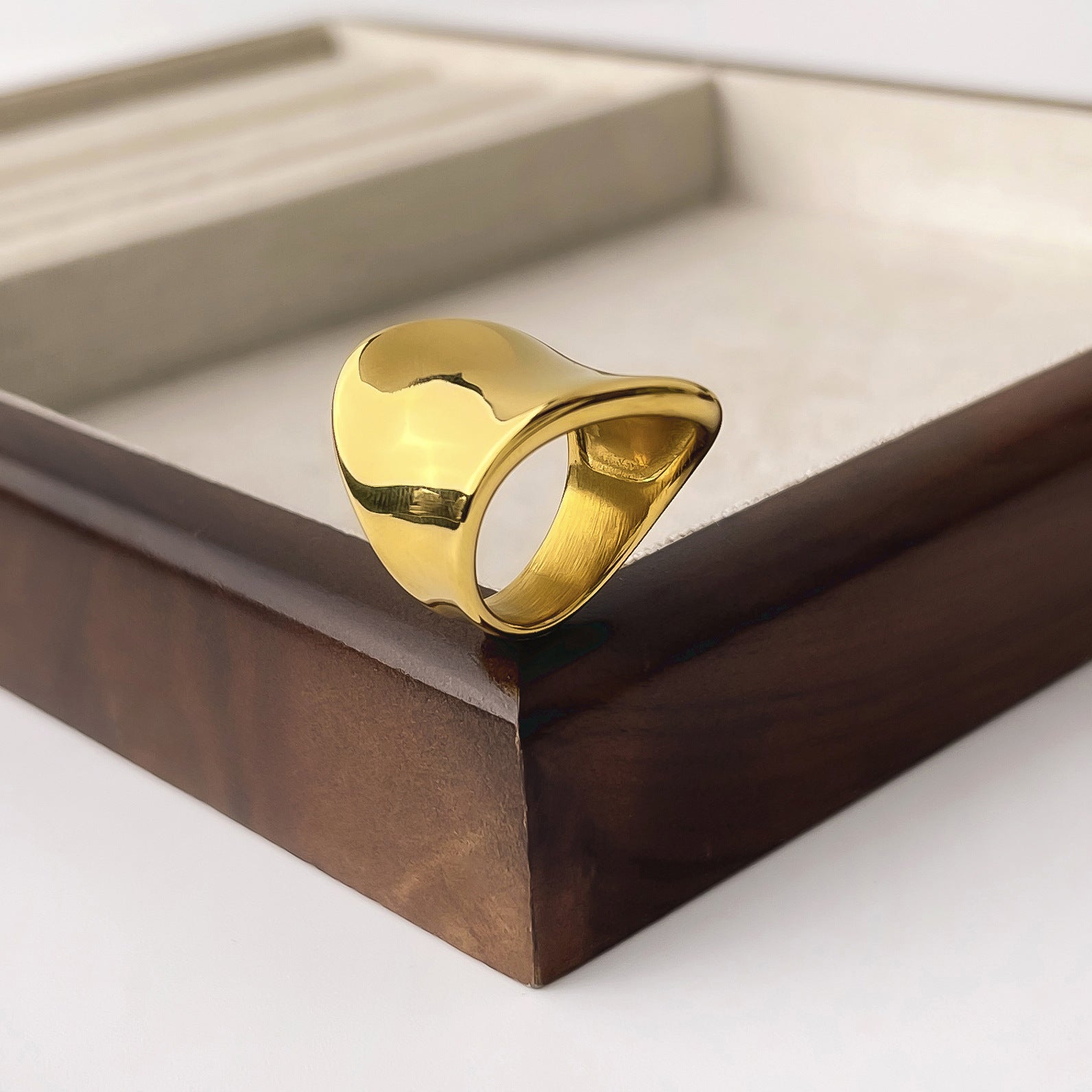 Skulptural ring i rostfritt stål guld minimalistisk design närbild