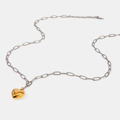 hjarthalsband i rostfritt stål med guldpläterat hjärta utlagt mot vit bakgrund