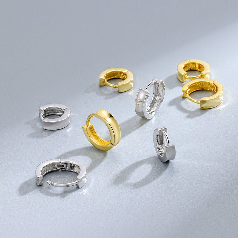 små hoop örhängen guld och silver, olikastorlekar utlagda mot grå bakgrund