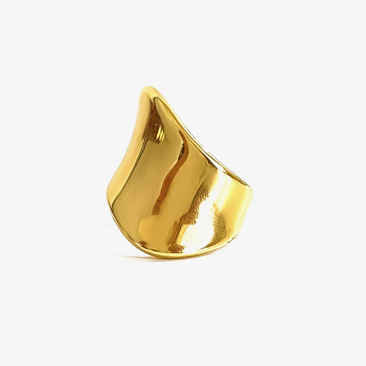 Skulptural ring i rostfritt stål guld minimalistisk design mot vit bakgrund