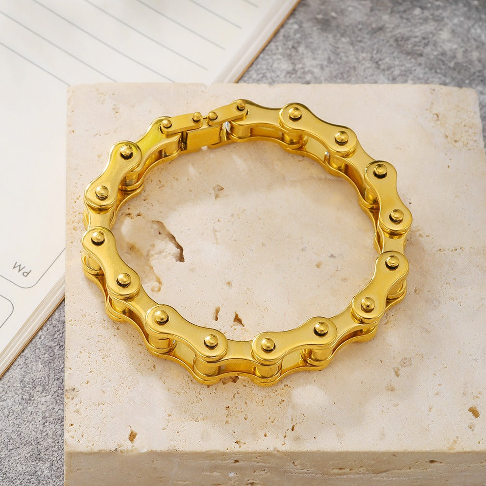 motorcykel kedjearmband rostfritt stål, guld liggandes på stenplatta