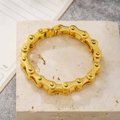 motorcykel kedjearmband rostfritt stål, guld liggandes på stenplatta