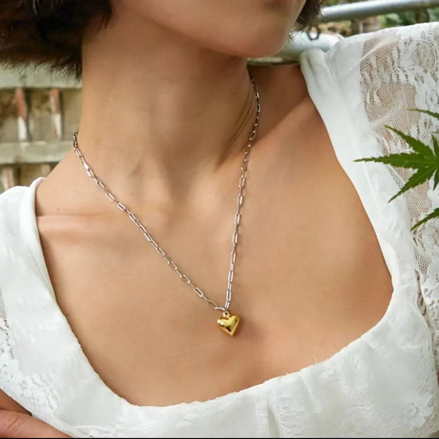 hjarthalsband i rostfritt stål med guldpläterat hjärta sedd på modell